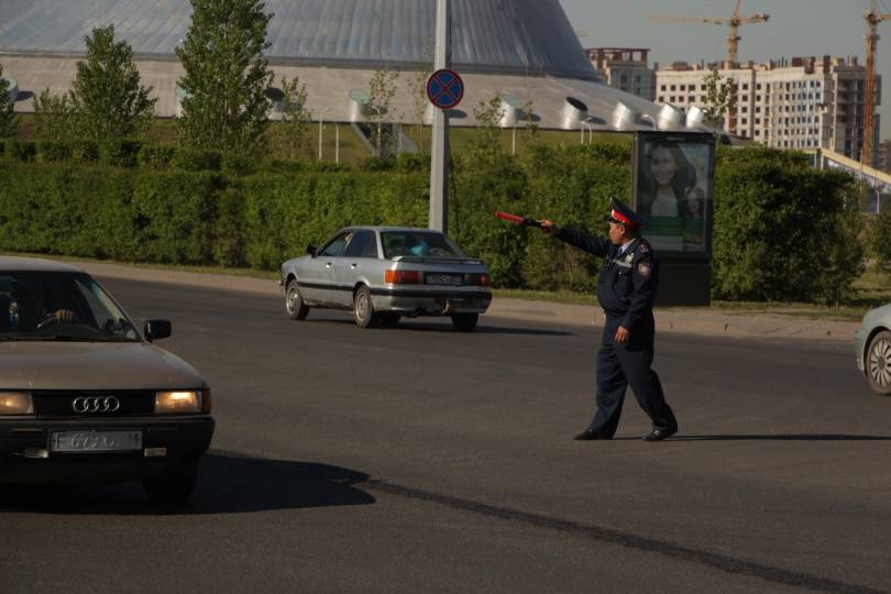 Полицейский регулирует движение транспорта по улице Туран