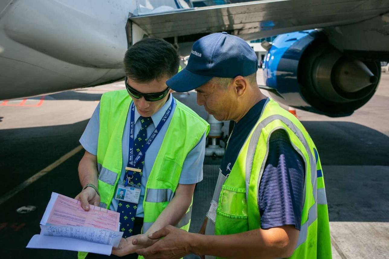 Представитель авиакомпании и приёмосдатчик при выгрузке багажа