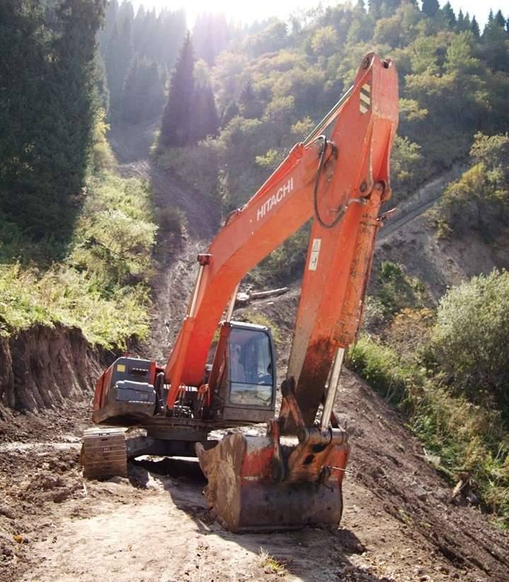 "Экскаватор в горах по дороге от базы "Енбек". За ним виден новый участок строительства дороги – она разделяется на две ветки, правая более благоустроена, видимо, влево попробовали строить, но было слишком круто"